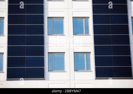 Weißes Gebäude mit Sonnenkollektoren an den Außenwänden. Stockfoto