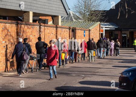 Leute, die Schlange stehen, um während Coronavirus Panikkauf im Vereinigten Königreich März 2020 einen Supermarkt zu betreten Stockfoto