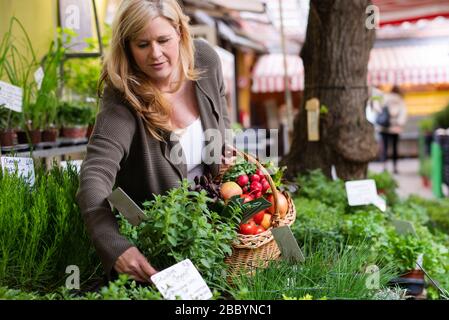 Eine attraktive Frau mittleren Alters kauft frische Produkte auf dem Markt Stockfoto