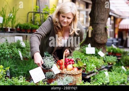 Eine attraktive Frau mittleren Alters kauft frische Produkte auf dem Markt Stockfoto