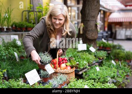Eine attraktive Frau mittleren Alters kauft frische Produkte auf dem Markt Stockfoto