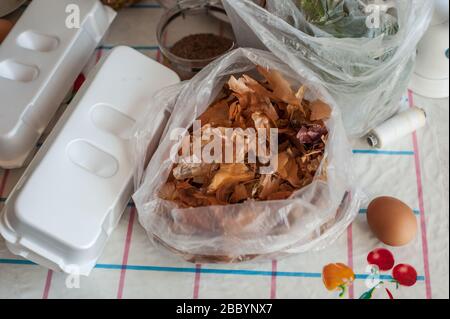 Vorbereitung für ein kreatives, Heimwerker-Osterei-Erlebnis: Hühnereier, Zwiebelhaut, Leinsamen, Strumpfhosen, Schnur und wasserbasierter Farbstoff. Stockfoto