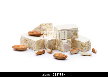 Kleine Nougat-Stücke mit Mandeln, auf weißem Hintergrund. Stockfoto