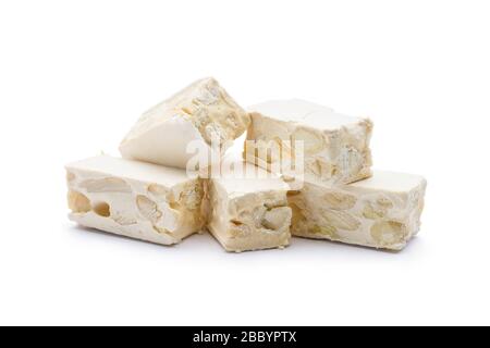 Kleine Nougat-Stücke auf weißem Hintergrund. Stockfoto