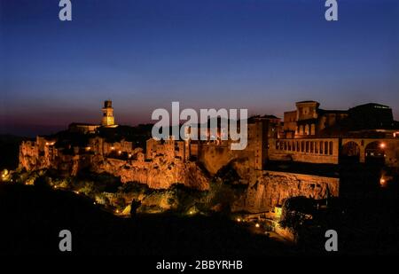 Herrlicher Blick auf das Dorf auf dem Tuff von Pitigliano, Grosseto, Toskana, Italien, beleuchtet durch das Abendlicht der blauen Stunde nach Sonnenuntergang Stockfoto