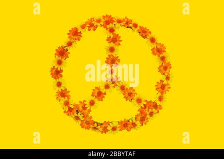 Friedenszeichen der Blumenkraft aus Blumen auf gelbem Hintergrund Stockfoto