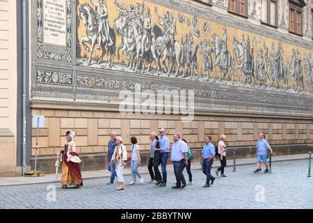 DRESDEN, DEUTSCHLAND - 10. MAI 2018: Touristen spazieren bei Furstenzug (Prinzenprozession), einem Wandmosaik aus bemalten Meißener Kacheln mit Prozession von Stockfoto