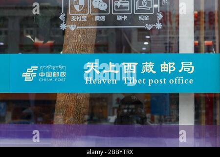 Das Fenster des zentralen Postamtes in Lhasa, Tibet. Auf dem Schild steht "Heaven Tibet Post Office" - beides in Englisch und Chinesisch. Stockfoto