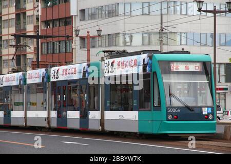 Hiroshima, JAPAN - 21. APRIL 2012: Menschen fahren mit der öffentlichen Straßenbahn in Hiroden in Hiroshima, Japan. Die Straßenbahnlinie feierte am 11. Mai 2012 ihr 100-jähriges Jubiläum Stockfoto