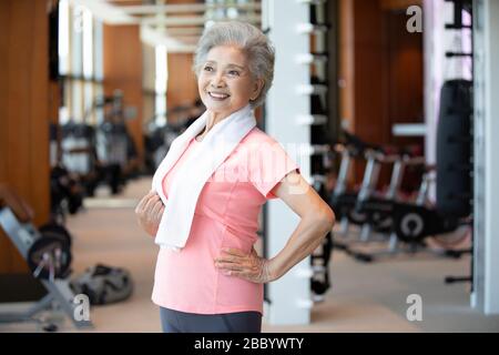 Ältere chinesische Frau, die nach dem Training im Fitnessstudio eine Pause einnahm Stockfoto