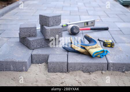 Pflastersteine Weg ebnet Hintergrund. Installation von Tools zur Vordergrund Stockfoto