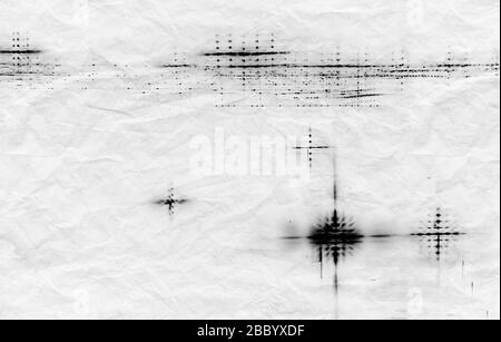 Abstraktes wissenschaftliches Hintergrundbild mit schwarzen Beugungsgitterflecken auf zerknittertem Papierblatt Stockfoto