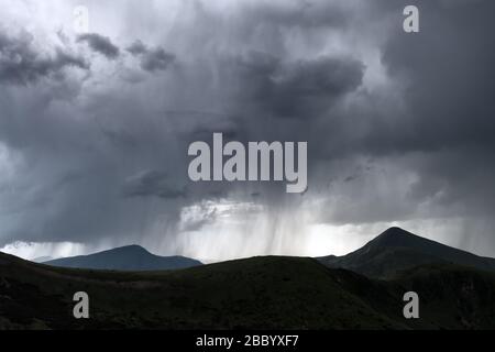 Erstaunliche Regenwolken in den Abendbergen. Schöne Natur der Karpaten. Landschaftsfotografie Stockfoto