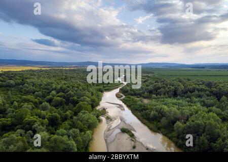 Fliegen Sie bei Sonnenuntergang durch den majestätischen Fluss Dnister und den üppigen grünen Wald. Ukraine. Landschaftsfotografie Stockfoto