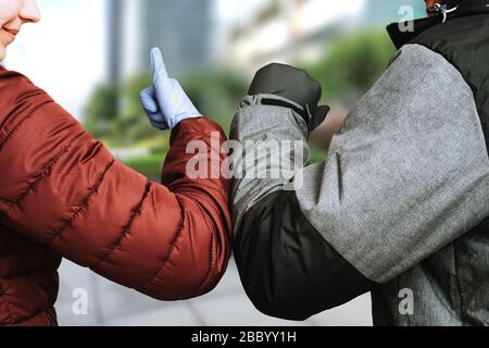 Ellenbogenschlag. Begrüßung, um die Ausbreitung von Coronavirus zu vermeiden. Frauen und Mannfreunde treffen sich. Corona Covid-19 Stockfoto