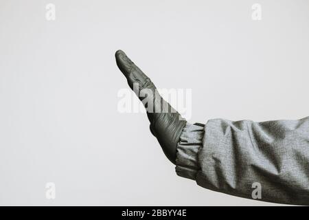 Hand in medizinischen Handschuhen, die den Anschlag auf Coronavirus Kovid-19 mit Text auf weißem Hintergrund verstellen Stockfoto