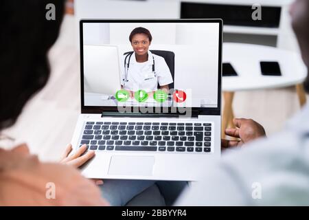Paare, Die Videochat Mit Doktor Auf Laptop Zu Hause Haben Stockfoto