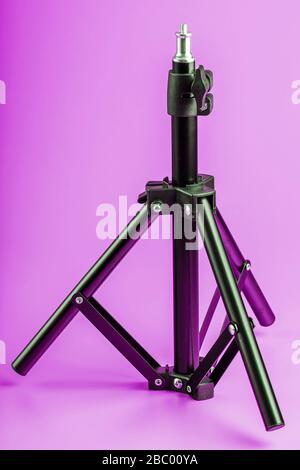 Stativ auf pinkfarbenem Hintergrund für Foto-Videokamera und Blitz. Freier Speicherplatz Stockfoto