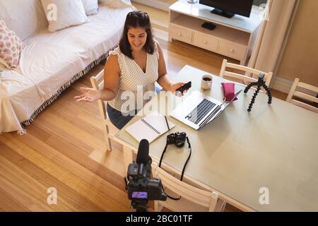 Selbstisolierender weiblicher Vlogger in der Größe Plus zu Hause Stockfoto