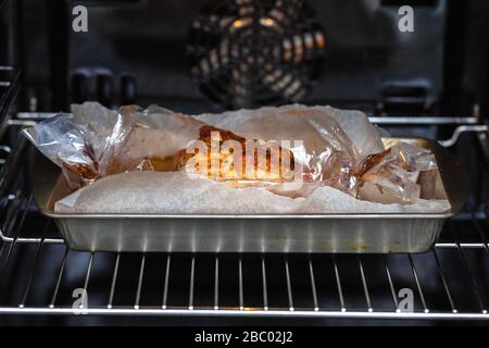 Das Fleisch mit Gewürzen wird im Ofen auf einer Metallbohrung in einer Muffe gebacken. Stockfoto