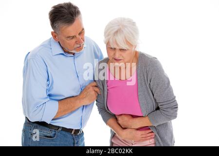 Mann hilft Frau mit Magenschmerzen Stockfoto