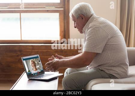 Glückliches älteres Paar spricht über Webcam mit Laptop Stockfoto