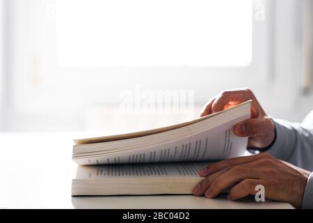 Öffnen eines Buches auf einem Tisch mit der Fensterbeleuchtung im Hintergrund Stockfoto