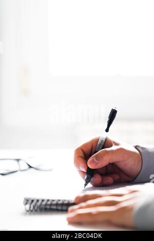 Halten Sie einen Stift in einem Notizbuch fest Stockfoto