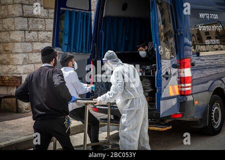 Jerusalem, Israel. April 2020. Mitglieder der Hevrat Kadisha, einer jüdischen Organisation, die Leichen verstorbener Juden für die Bestattung vorbereitet, transportieren die Leichen von Israelis, die nach ihrem Tod in Frankreich nach dem Abschluss eines Coronavirus repatriiert wurden. Kredit: Ilia Yefimovich / dpa / Alamy Live News Stockfoto