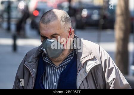 Beirut, Libanon. April 2020. Ein männlicher Fußgänger, der eine chirurgische Maske als Schutz vor kovisanten 19 Infektionen trägt, während sich die Beiruter Bürger während der Sperrzeit und der wirtschaftlichen Not an das Leben anpassen, nachdem die Regierung Quarantäne und nächtliche Sperrungen angeordnet hatte, die die Ausbreitung des neuen Coronavirus eindämmen sollten. Das neuartige Coronavirus verursacht für die meisten Menschen leichte oder mäßige Symptome, für ältere Erwachsene und Menschen mit bestehenden Gesundheitsproblemen kann es jedoch zu schwerer Krankheit oder Tod führen. Credit: amer ghazzal/Alamy Live News Stockfoto