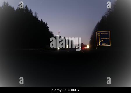 Auf dem Weg auf der A95 von München nach Garmisch. Auf dieser bei Rasern sehr beliebten Strecke kommt es zu vielen Unfällen. Abendatmosphäre auf der Autobahn aus Sicht des Fahrers. [Automatisierte Übersetzung] Stockfoto