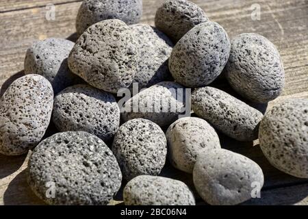 Eine Gruppe runder Lavasteine, kleine Naturlavasteine im Hintergrund Stockfoto