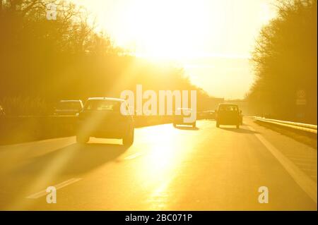 Auf dem Weg auf der A95 von München nach Garmisch. Auf dieser bei Rasern sehr beliebten Strecke kommt es zu vielen Unfällen. Hier blendendes Gegenlicht bei Sonnenuntergang. [Automatisierte Übersetzung] Stockfoto