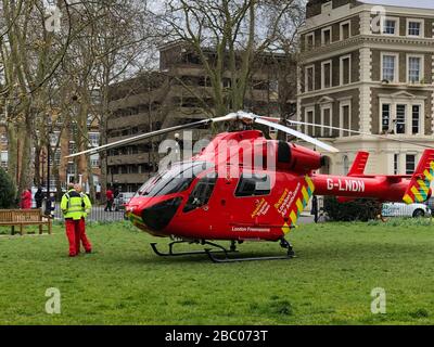 London, Großbritannien. April 2020. Londons Flugkrankenwagen G-LNDN Helikopter landet in der Grünanlage Albert Square. Stockfoto