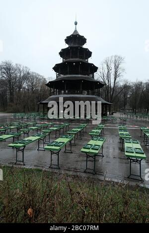 Der Biergarten am chinesischen Turm ist menschenleer. Die Tische und Bierbänke sind mit einem Flatterband verschlossen - Ausstiegsbeschränkung in Bayern wegen Corona-Pandemie - Tag 1, München am 21.03.2020. [Automatisierte Übersetzung] Stockfoto