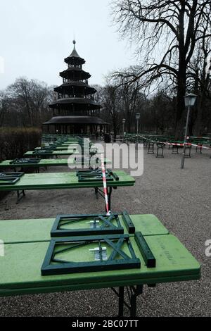 Der Biergarten am chinesischen Turm ist menschenleer. Die Tische und Bierbänke sind mit einem Flatterband verschlossen - Ausstiegsbeschränkung in Bayern wegen Corona-Pandemie - Tag 1, München am 21.03.2020. [Automatisierte Übersetzung] Stockfoto