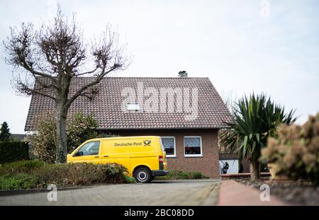 Gangelt Birgden, Deutschland. April 2020. Ein Auto der Deutschen Post wird vor einem Mietshaus geparkt. Im Kreis Heinsberg, der besonders vom Coronavirus betroffen ist, startet die Deutsche Post ein Pilotprojekt zur Bereitstellung von Grundleistungen für Risikogruppen, die von der Deutschen Post mit Lebensmitteln und Haushaltswaren des örtlichen Einzelhandels versorgt werden können. Credit: Jonas-Güttler / dpa / Alamy Live News Stockfoto