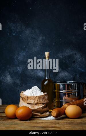 Kochen und Backen. Alte Küche mit Produkten und Zutaten (Mehl, Butter, Eier) für Teig und Backbrot, Pasta und Pizza. Stockfoto