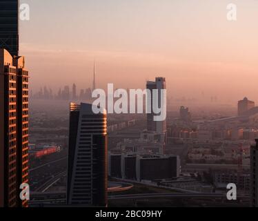 Skyline von Dubai mit Blick auf Burj Khalifa bei nebeligem Sonnenaufgang. Stockfoto
