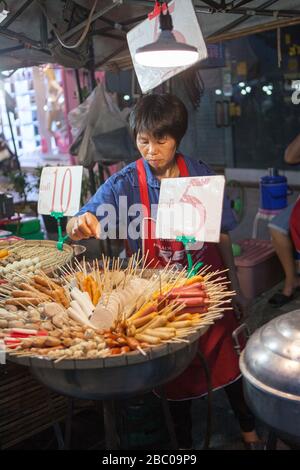 Nachtbasar und Lebensmittelgericht im Zentrum der Stadt Chiang Rai. Es besteht aus vielen kleinen Ständen, die die enge Straße säumten. Lebensmittel zum Verkauf. Stockfoto
