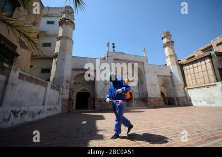 Peschawar, Pakistan. April 2020. Die Mitglieder des Teams der städtischen Körperschaft sprühen Desinfektionsmittel, um die Umgebung der Dilawar Khan Moschee und Straße nach einem Ausbruch des Corona-Virus in der Stadt Peschawar, Pakistan, zu sanieren. (Foto von Hussain Ali/Pacific Press) Credit: Pacific Press Agency/Alamy Live News Stockfoto