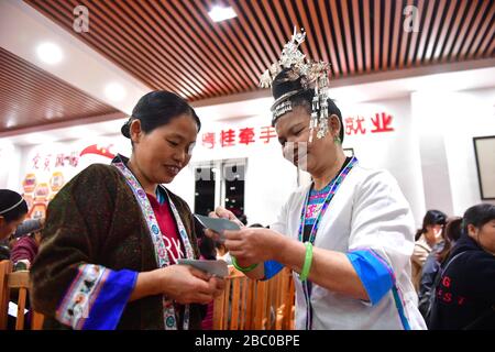 (200402) -- NANNING, 2. April 2020 (Xinhua) -- Einheimische üben Stickereien in einem Workshop zur Armutsbekämpfung in einem Umsiedlungsort im Autonomen Kreis Rongshui Miao, Südchina Autonomes Gebiet Guangxi Zhuang, 18. November 2019. Die Autonome Region Guangxi Zhuang, eine Schlüsselregion in Chinas Anti-Armut-Bemühungen, hat dazu geführt, dass etwa 710.000 Menschen, die während der 13. Fünfjährigen Planungsperiode (2016-2020) aus unwirtlichen Gebieten umgesiedelt wurden, als Schlüsselkampf gegen Armut identifiziert und Akten eingerichtet wurden. Das Umzugsprogramm wurde Ende letzten Jahres abgeschlossen. Viele Menschen wurden aus der Umgebung entfernt Stockfoto