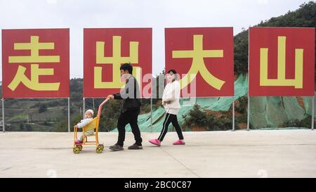 (200402) -- NANNING, 2. April 2020 (Xinhua) -- Einwohner Unternehmen einen Spaziergang in einem Umsiedlungsort zur Armutsbekämpfung im Kreis Longlin im Süden Chinas im Autonomen Gebiet Guangxi Zhuang, 3. Dezember 2019. Die Autonome Region Guangxi Zhuang, eine Schlüsselregion in Chinas Anti-Armut-Bemühungen, hat dazu geführt, dass etwa 710.000 Menschen, die während der 13. Fünfjährigen Planungsperiode (2016-2020) aus unwirtlichen Gebieten umgesiedelt wurden, als Schlüsselkampf gegen Armut identifiziert und Akten eingerichtet wurden. Das Umzugsprogramm wurde bis Ende letzten Jahres abgeschlossen.eine große Anzahl von Menschen aus der ökologisch anfälligen Bergree herausführen Stockfoto