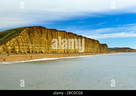 Besucher, die den Sommer in West Bay in der Nähe von Bridport an der Jurassic Coast, Dorset, Großbritannien, genießen Stockfoto