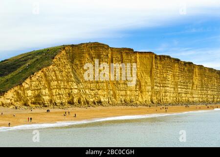 Besucher, die den Sommer in West Bay in der Nähe von Bridport an der Jurassic Coast, Dorset, Großbritannien, genießen Stockfoto