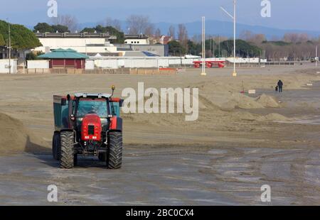 Rotes Arbeitsfahrzeug an einem sandigen Strand Stockfoto
