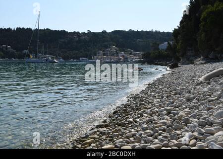 Kieselstrand an der Lakka Bay. Ein kleines touristisches Dorf auf der Spitze der Insel Paxos. Griechische Insel. Stockfoto