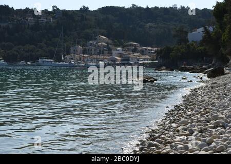 Kieselstrand an der Lakka Bay. Ein kleines touristisches Dorf auf der Spitze der Insel Paxos. Griechische Insel. Stockfoto