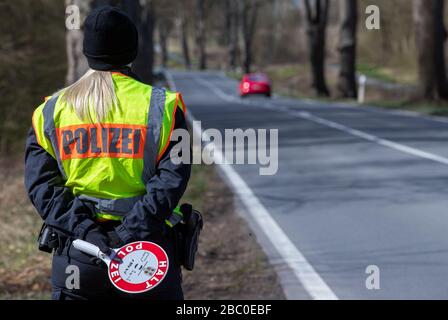 02. April 2020, Mecklenburg-Vorpommern, Dechow: Auf der Bundesstraße B208 an der Landesgrenze zwischen Mecklenburg-Vorpommern und Schleswig-Holstein überprüfen Polizeibeamte Fahrzeuge, die in Mecklenburg-Vorpommern nicht zugelassen sind. Mit diesen Kontrollen will die Landesregierung Mecklenburg-Vorpommern einen weiteren Zustrom von Touristen stoppen, um die weitere Verbreitung des Corona-Virus zu verlangsamen. Foto: Jens Büttner / dpa-Zentralbild / dpa Stockfoto