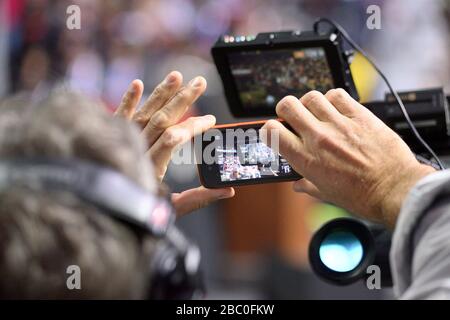 Der Kamerabetreiber nutzt das Handy, um die Anzeige des Nachrichtensuchers während der politischen Kundgebung in Philadelphia, PA, am 2. November 2014 festzuhalten. Stockfoto